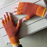 Pair of striped orange and purple gloves on a light wooden surface