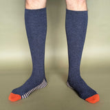 Knee-high blue socks with orange toes on a beige background