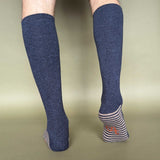 Knee-high blue socks with striped cuffs on a beige background