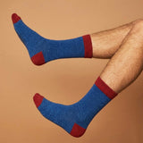 A PAIR OF NAVY BLUE WOOL SOCKS WITH DARK RED RIB HEEL AND TOE ON A BROWN BACKGROUND