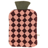 A knitted hot water bottle cover with a pink and dark brown argyle diamond pattern and an olive green ribbed neck, shown on a plain white background.