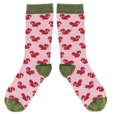 Pink socks with red squirrel pattern and green accents on a white background